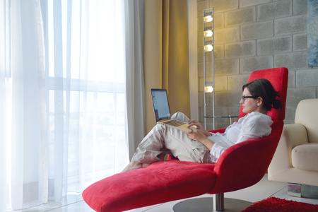 adult, beautiful, beauty, brunette, casual, caucasian, computer, couch, face, female, fun, girl, happy, home, house, indoor, indoors, interior, internet, keyboard, laptop, leisure, life, lifestyle, living, living room, modern, notebook, one, online, peoplの写真素材