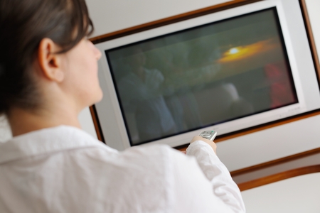 happy young woman watching tv at modern home livingroomの写真素材