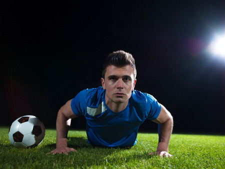soccer player doing kick with ball on football stadium  field  isolated on black backgroundの写真素材