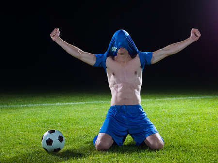 soccer player doing kick with ball on football stadium  field  isolated on black backgroundの写真素材
