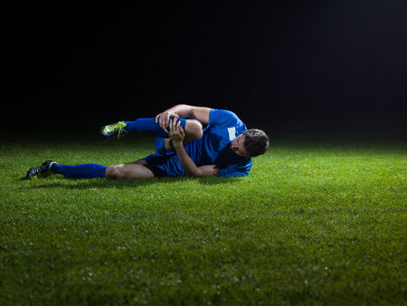 soccer player doing kick with ball on football stadium  field  isolated on black backgroundの写真素材