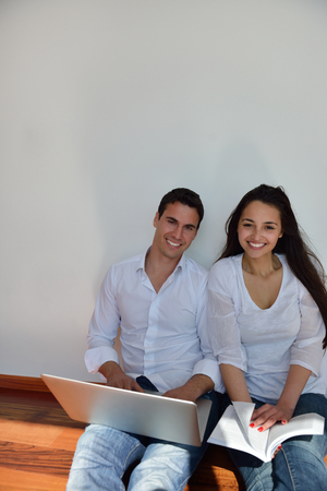 happy young relaxed  couple working on laptop computer at modern home indoorの写真素材