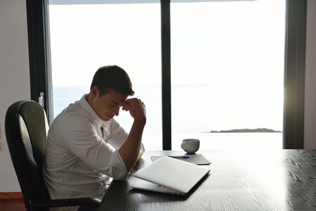 frustrated with problems young business man working on laptop computer at home