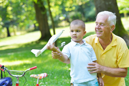 happy grandfather and child have fun and play in parkの写真素材