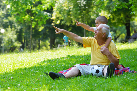 happy grandfather and child have fun and play in parkの写真素材