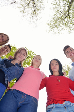 Happy smiling group of young friends staying together outdoor in the parkの写真素材