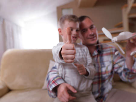 father and son assembling airplane toy at modern home living room indoorの写真素材