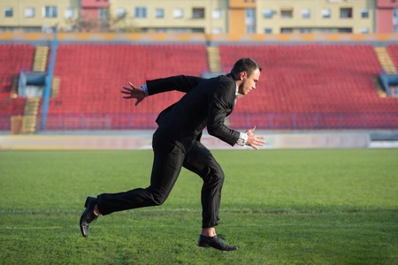 business man in start position ready to run and sprint on athletics racing trackの写真素材