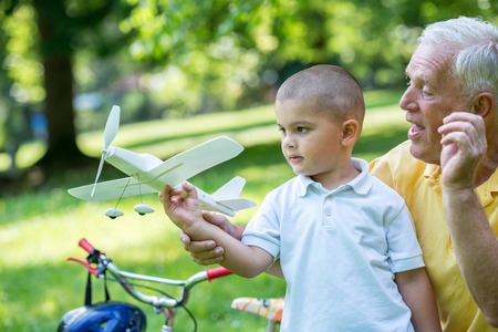 happy grandfather and child have fun and play in park on beautiful  sunny dayの写真素材