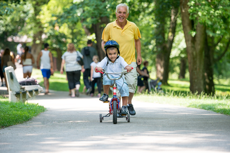 happy grandfather and child have fun and play in park on beautiful  sunny dayの写真素材