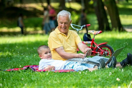 grandfather and child using tablet computer in parkの写真素材