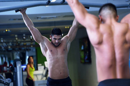 Strong handsome man exercising at the gym