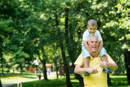 happy grandfather and child have fun and play in park on beautiful  sunny dayの写真素材