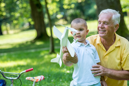 happy grandfather and child have fun and play in park on beautiful  sunny dayの写真素材