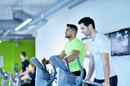 group of young people running on treadmills in modern sport  gym
