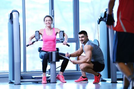 Gym woman exercising with her personal trainerの写真素材