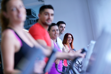 group of young people running on treadmills in modern sport  gymの写真素材