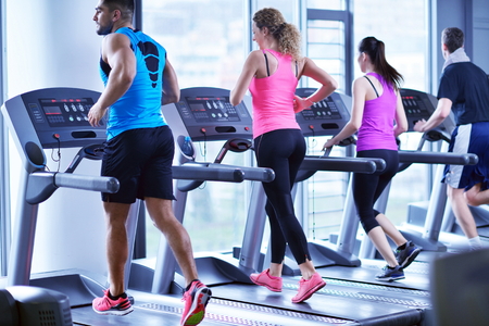 group of young people running on treadmills in modern sport  gymの写真素材