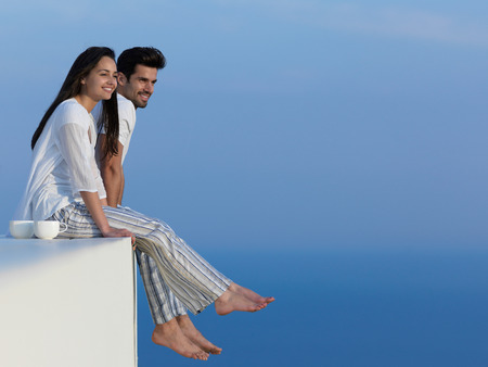 happy young romantic couple have fun relax smile at modern home outdoor terace balcony teraceの写真素材