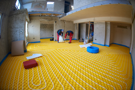 Group of worker installing underfloor heating and colling in modern homeの写真素材