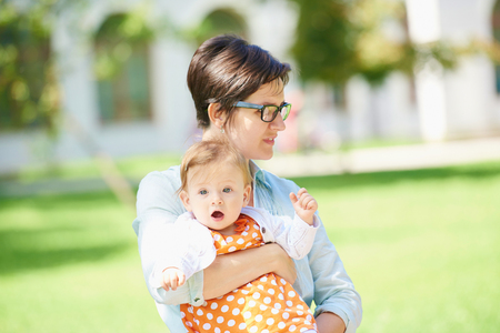 Portrait of happy mom and baby daughter smiling at park natureの写真素材