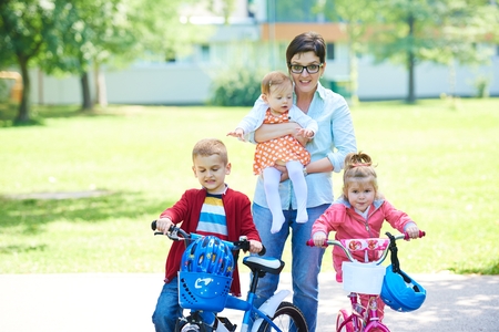 happy family playing together outdoor  in park mother with kids  running on grass