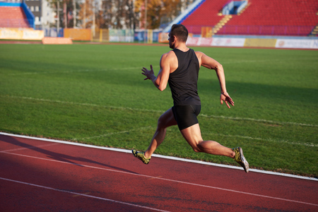 Sprinter leaving starting blocks on the running track. Explosive start.