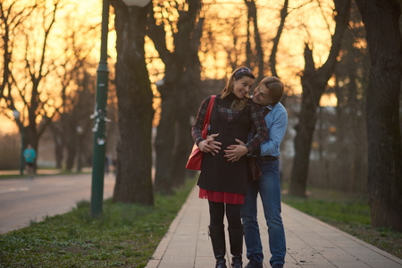 Happy and young pregnant couple have fun and relax outdoorの写真素材