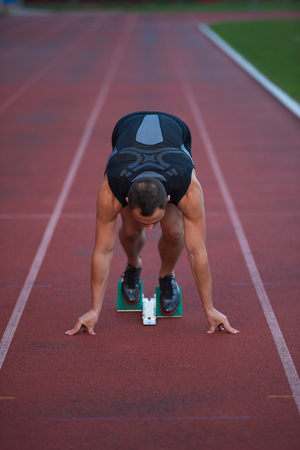 Sprinter leaving starting blocks on the running track. Explosive start.の写真素材