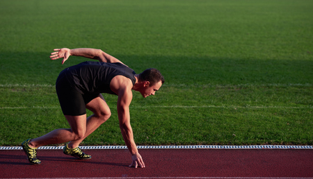 Sprinter leaving starting blocks on the running track. Explosive start.の写真素材