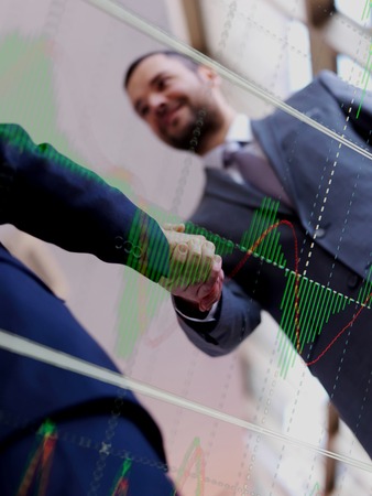 Double exposure design. Business partners, partnership concept with two businessman handshakeの写真素材