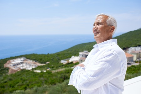 senior man in front of luxury modern home villaの写真素材