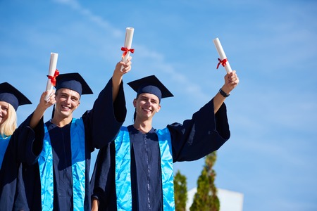 young graduates students group  standing in front of university building on graduation dayの写真素材
