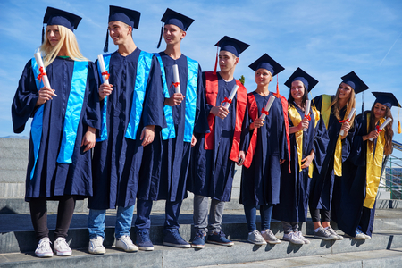 young graduates students group  standing in front of university building on graduation dayの写真素材