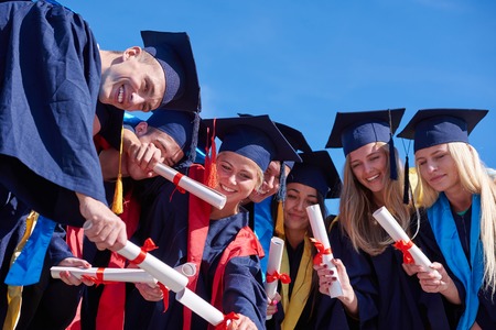young graduates students group  standing in front of university building on graduation day