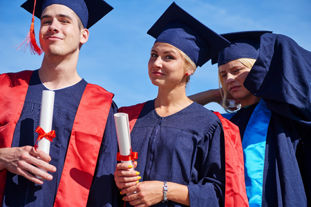 young graduates students group  standing in front of university building on graduation dayの写真素材