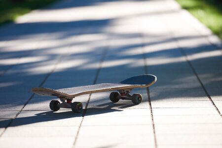 Old used skateboard isolated on the ground on streetの写真素材
