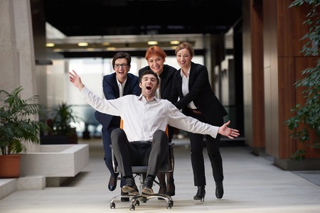 business people group at modern office indoors have fun and push office chair on corridorの写真素材