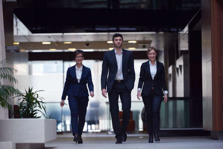young business people team walking, group of people on modern office hall interiorの写真素材
