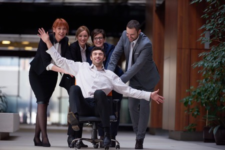 business people group at modern office indoors have fun and push office chair on corridorの写真素材