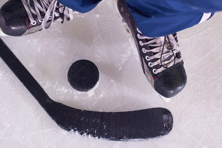 two hockey sticsk and puck on ice, start of the game, competition concept in business, top view