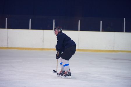 ice hockey player in action kicking with stickの写真素材