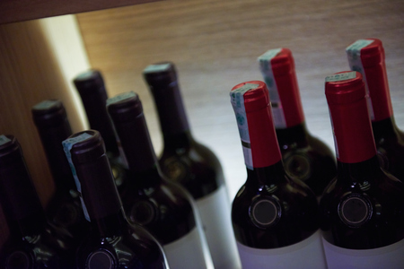Wine bottles on a wooden shelf in modern restaurant interior