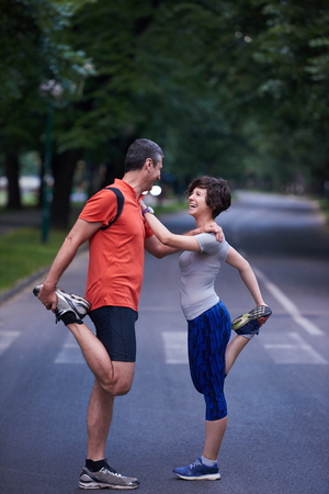 jogging couple warming up and stretching before runningの写真素材