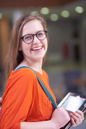 happy student girl working on tablet computer at modern school university indoorsの写真素材