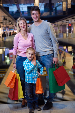 happy  young family with shopping bags in mallの写真素材