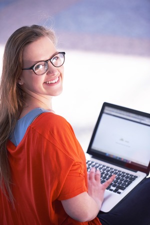 happy student girl working on laptop computer at modern school university indoorsの写真素材