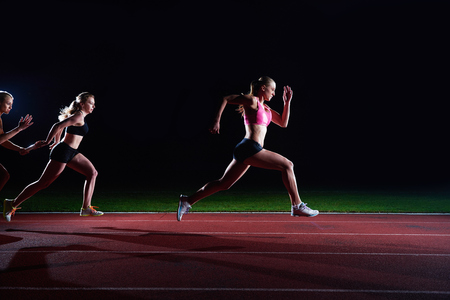 woman athletic runners passing baton in relay raceの写真素材