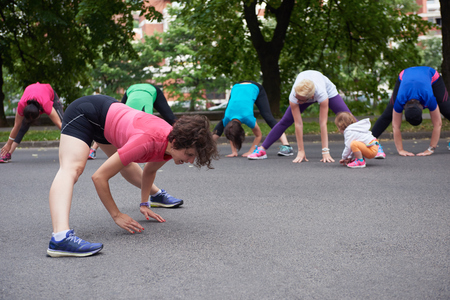 jogging people group stretching in park before trainingの写真素材