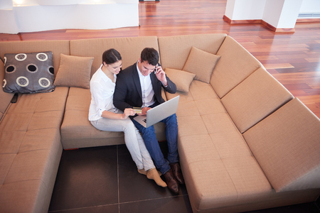 happy young relaxed  couple working on laptop computer at modern home interiorの写真素材